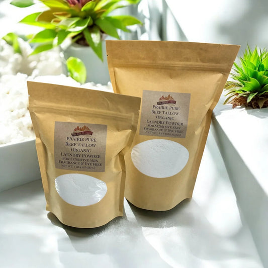 Organic beef tallow laundry powder in brown resealable bags for sensitive skin, with plants nearby.