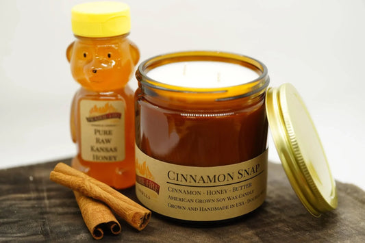 Cinnamon Snap soy wax candle in amber jar with honey bottle and cinnamon sticks