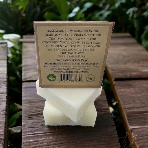 Back of grass-fed beef tallow soap bar with ingredient label, outdoors on wood surface