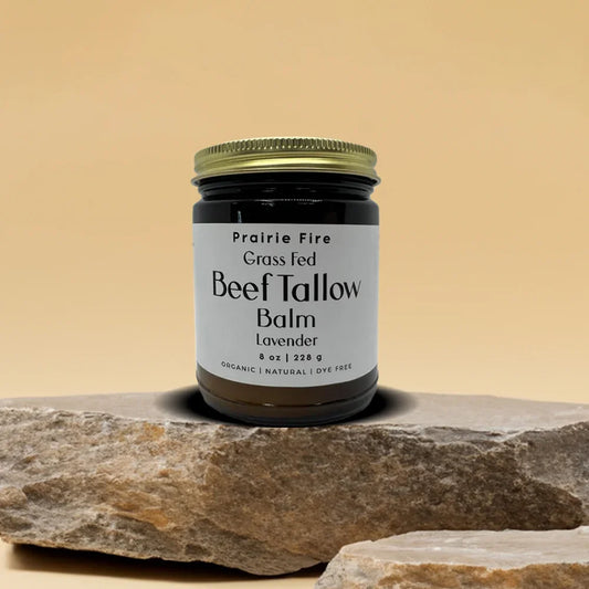 Grass-fed beef tallow balm jar with lavender scent on stone against beige background