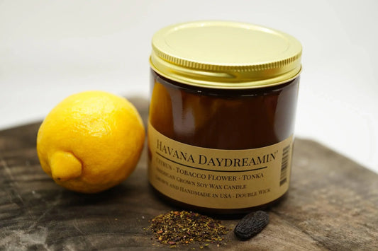 Amber jar Havana Daydreamin' soy wax candle with lemon, spices, and tonka bean on wood.