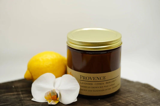 Provence lavender citrus soy candle in an amber jar with lemon and white orchid flower