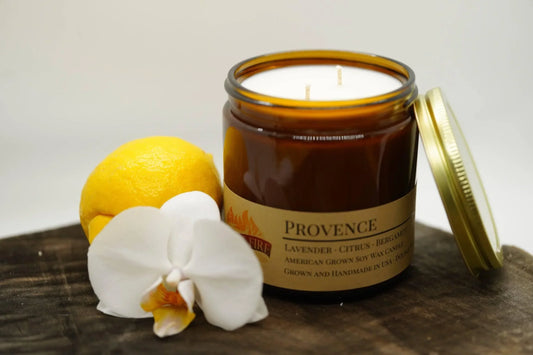 Amber jar Provence lavender citrus soy candle with a lemon and white orchid on wood surface