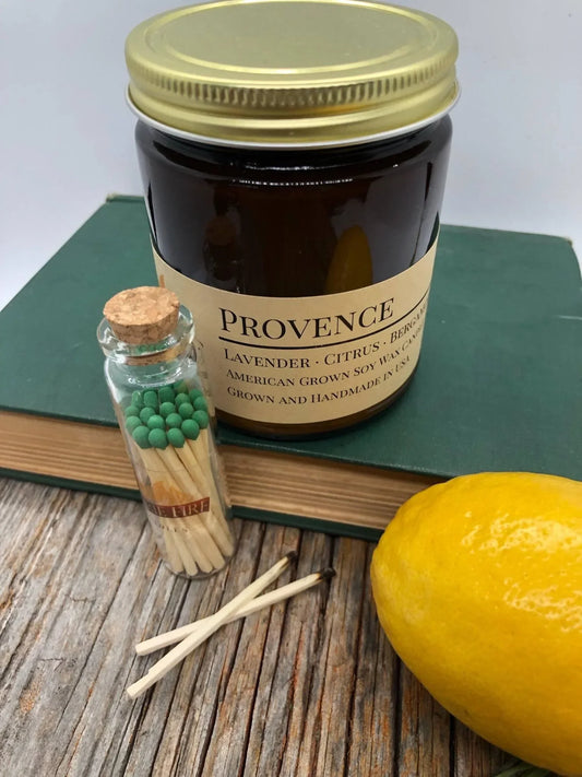 Amber jar Provence lavender citrus soy candle with matches and lemon on rustic wood