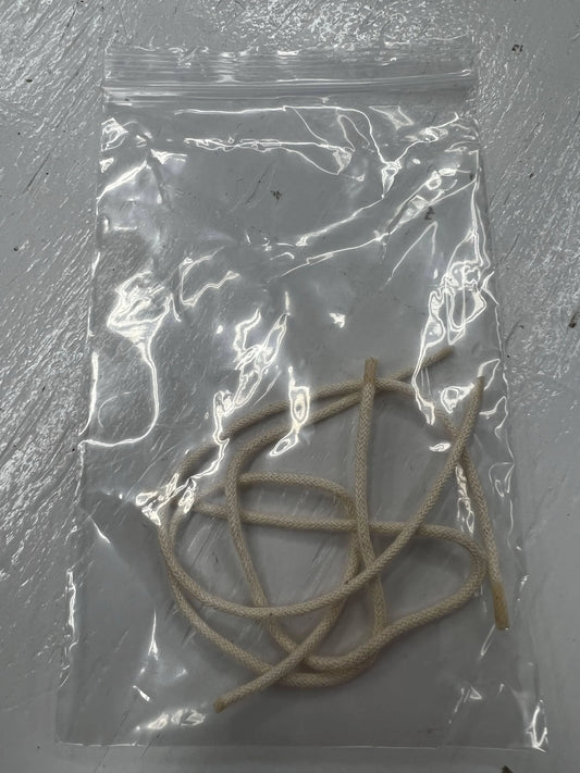 Replacement cotton candle wicks in clear plastic bag on white surface