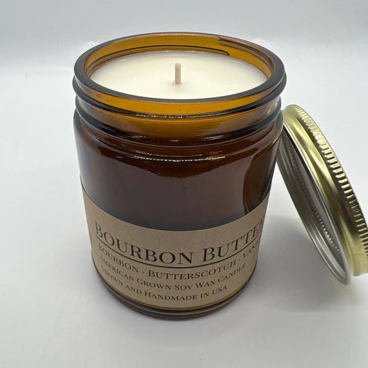 Bourbon butterscotch scented soy wax candle in amber glass jar with cotton wick and gold lid